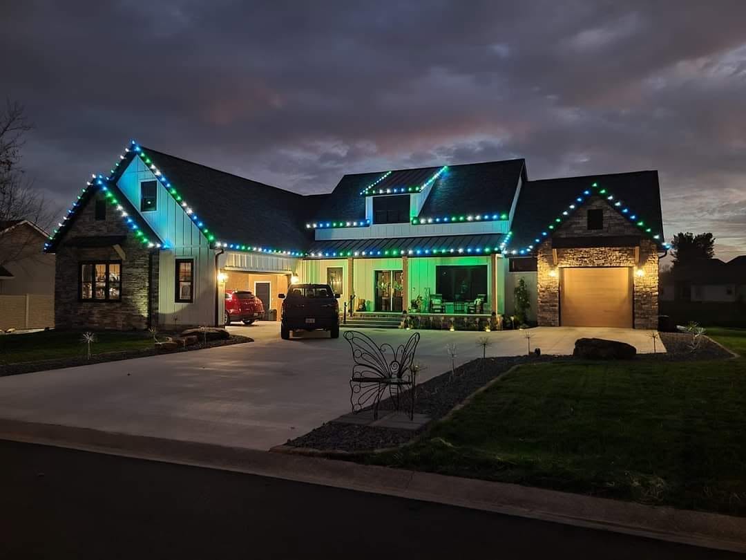 Home outlined with blue and green roofline lights at dusk