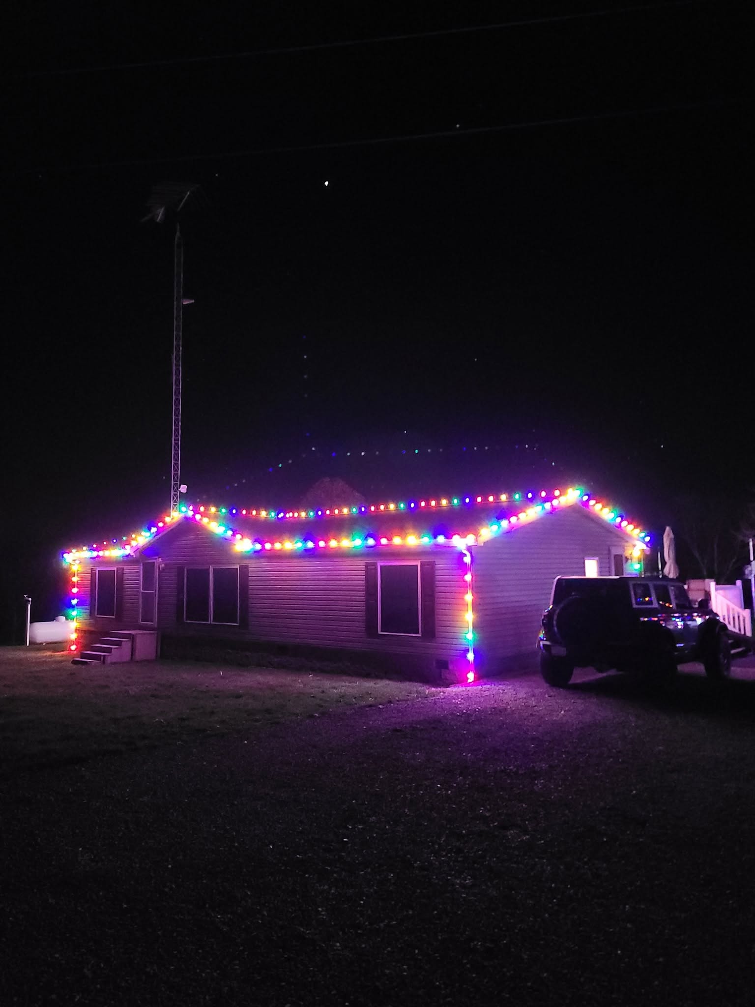 Single-story home decorated with multicolor holiday lights at night