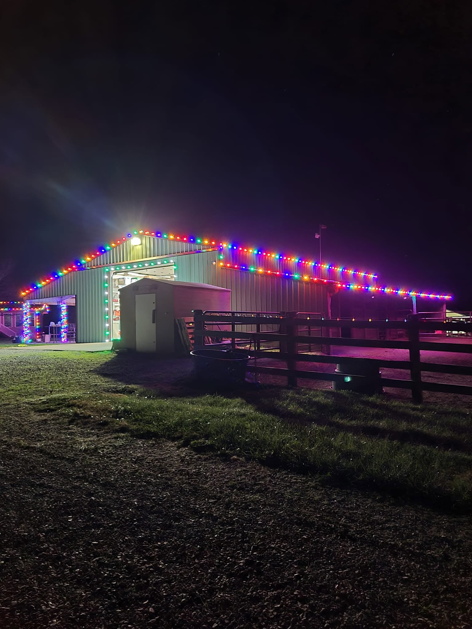 Large barn outlined with multicolor holiday lights