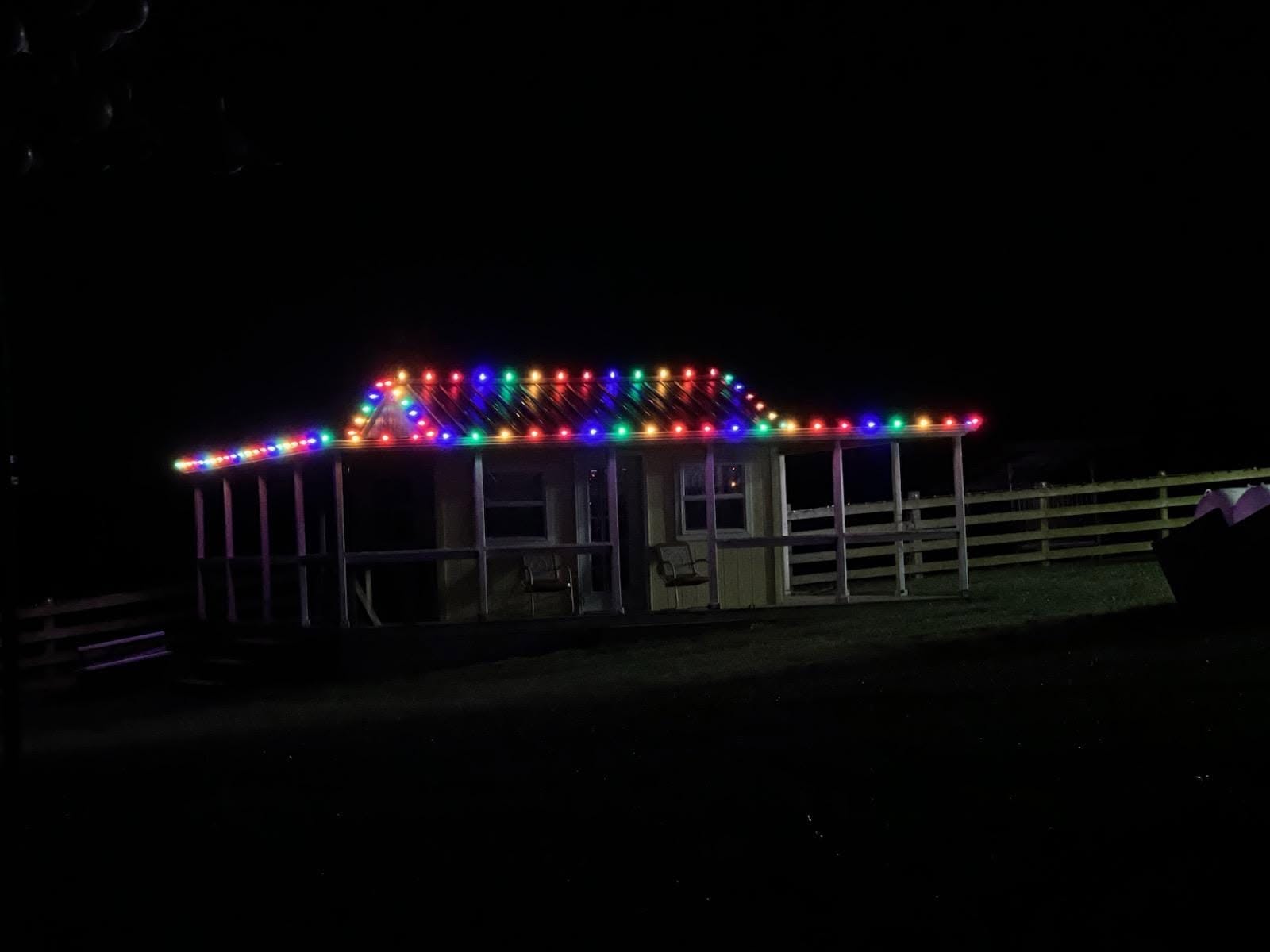 Cabin roofline decorated with multicolor holiday lights