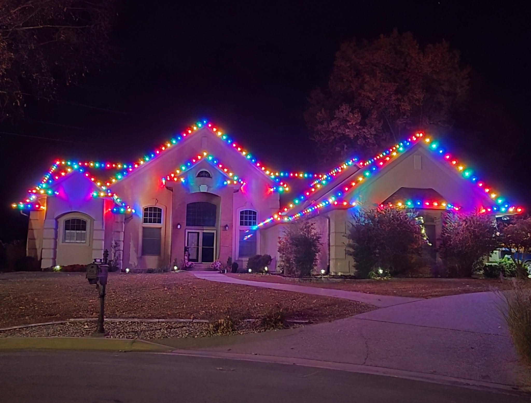 Kokopelli home covered in vivid multicolor roofline lights