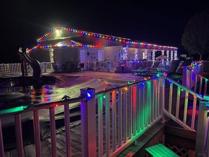Pool deck and building decorated with multicolor holiday lights