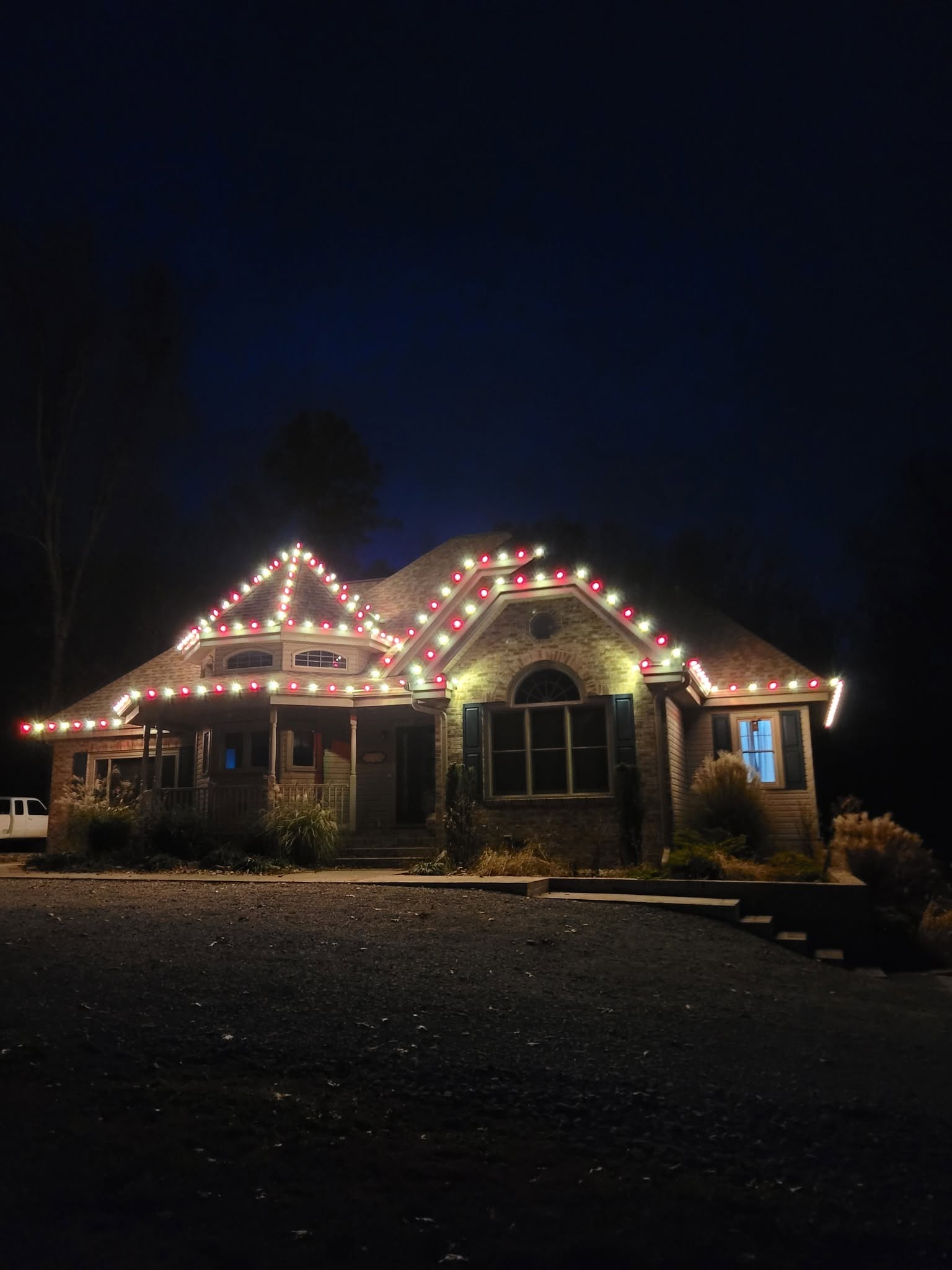 Brick home with red and warm white roofline lights