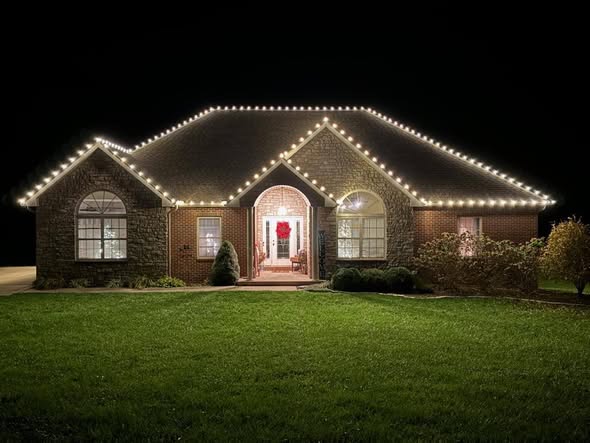 Brick home viewed from the front with warm white roofline lighting