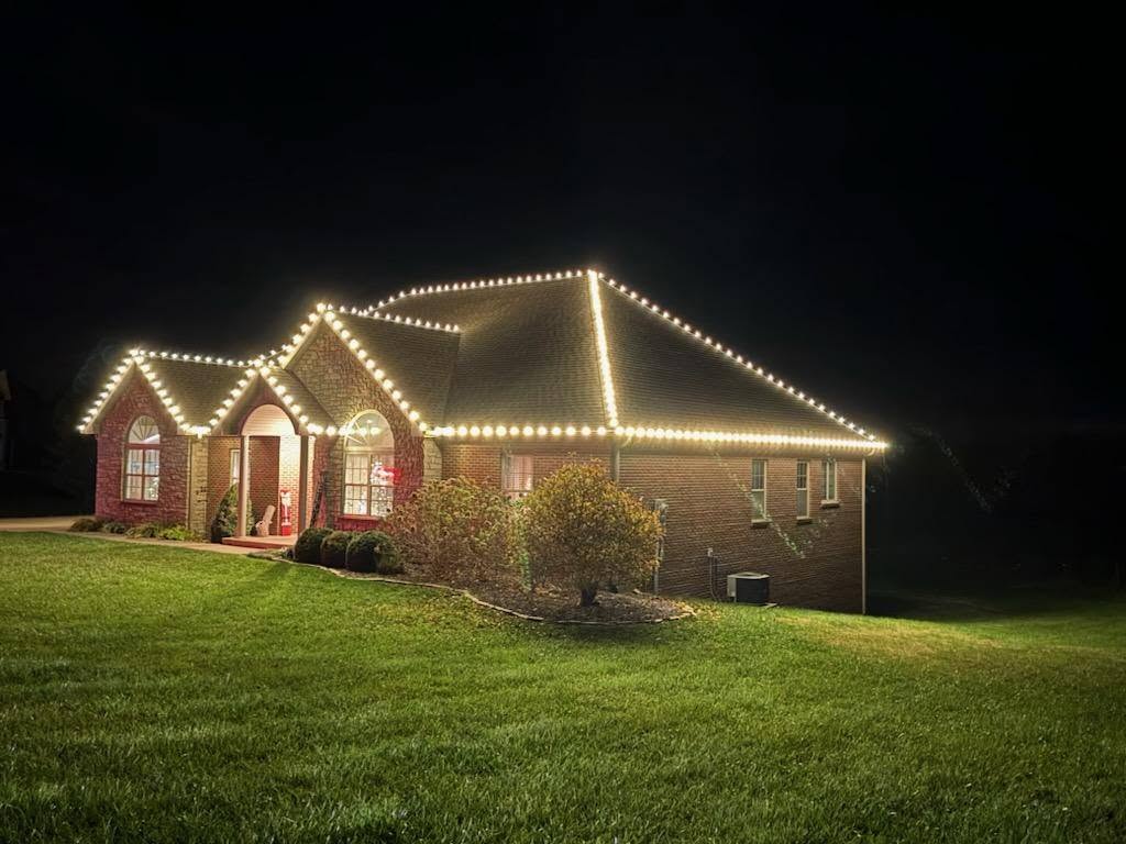 Brick home viewed from the side with warm white roofline lighting